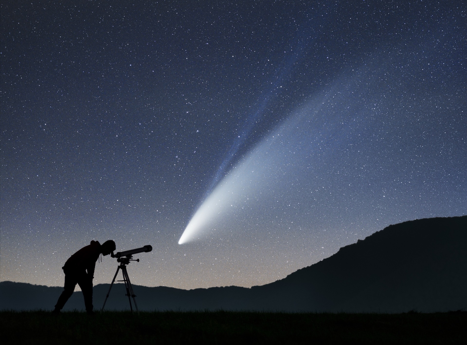 Comet NEOWISE over a night horizon with a stargazer silhouette